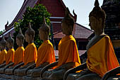 Ayutthaya, Thailand. Wat Yai Chai Mongkhon, saffron-draped Buddha statues inside the temple compound. 